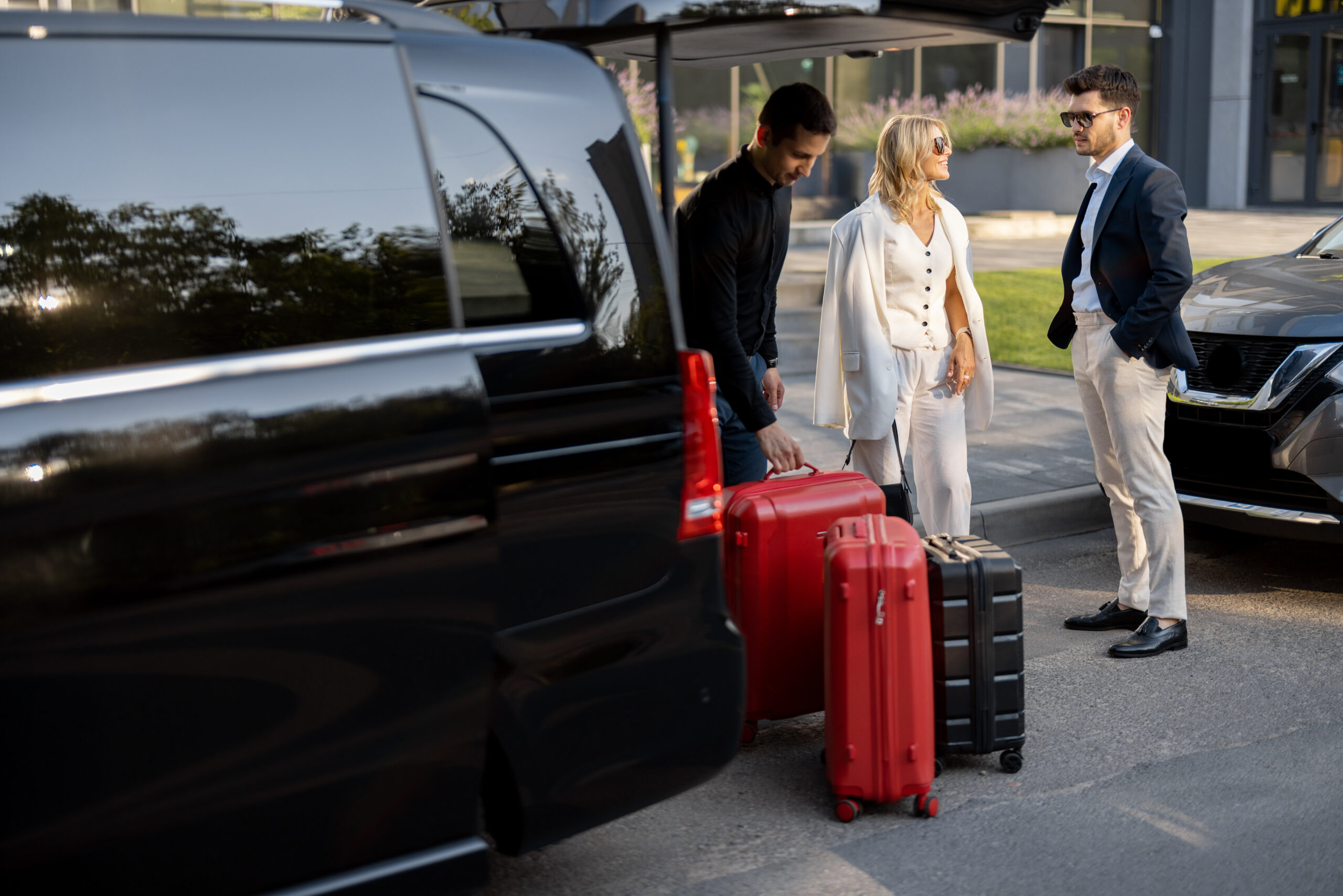 business-couple-near-minivan-taxi-with-a-suitcases-and-chauffeur